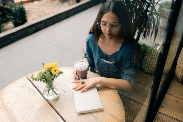 Een meisje dat smoothies drinkt in een café. Hoge kwaliteit foto - Foto, afbeelding