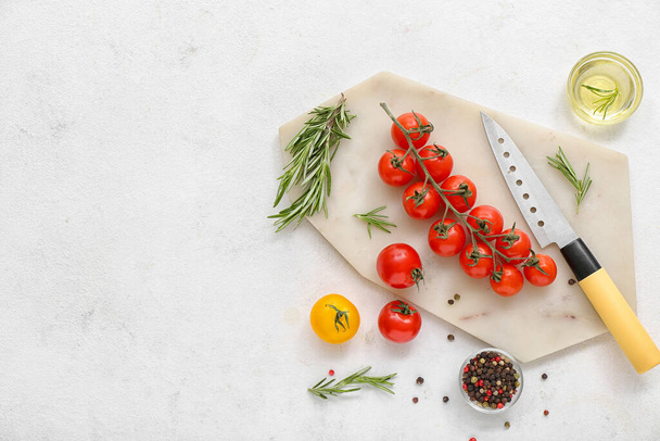 Доска со свежими помидорами черри и розмарином на белом фоне - Фото, изображение