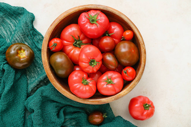 Cuenco con diferentes tomates frescos sobre fondo blanco - Foto, imagen
