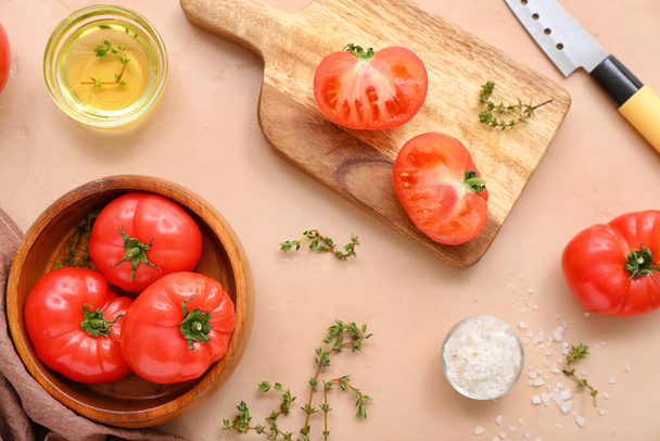 Cuenco y tabla con tomates frescos sobre fondo beige - Foto, Imagen