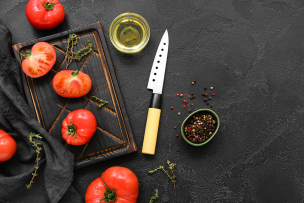 Tablero con tomates frescos sobre fondo negro - Foto, imagen