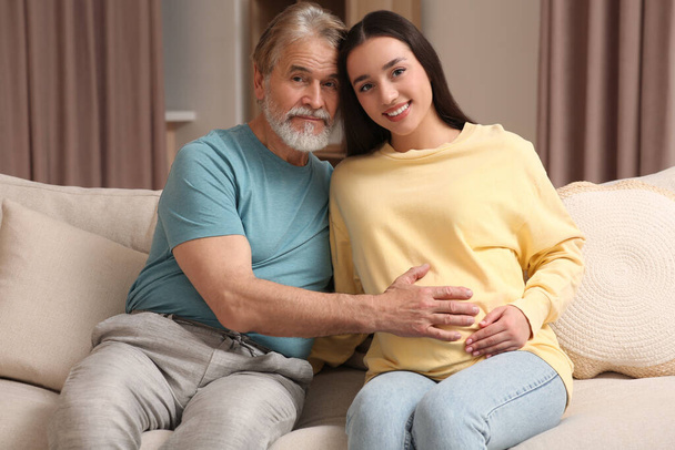 Father and his pregnant daughter indoors. Grandparents' reaction to future grandson - Zdjęcie, obraz