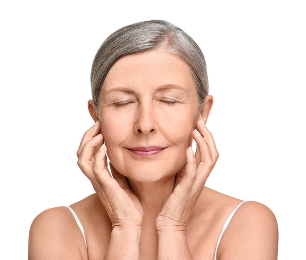 Portrait of senior woman with aging skin on white background. Rejuvenation treatment - 写真・画像
