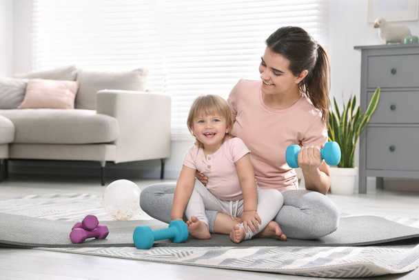 Mother and her daughter with dumbbells at home - Photo, Image