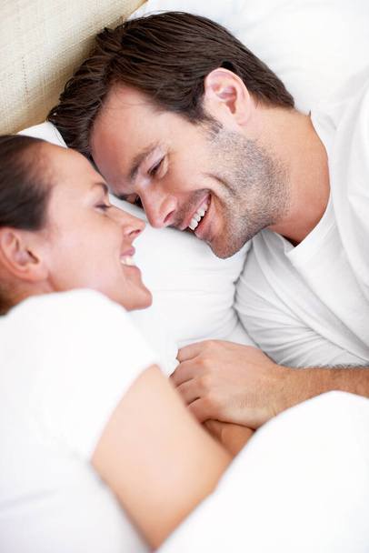 You always make me laugh. Portrait of a young couple lying in bed and laughing - Foto, Imagem