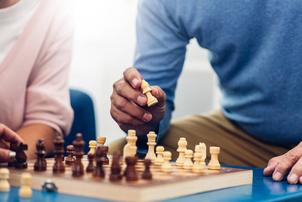 Person playing chess board game. Older Man playing chess. Hand of Senior man moving chess in success play. strategy, Management or leadership concept. concept of business strategy and tactic - Foto, Imagen