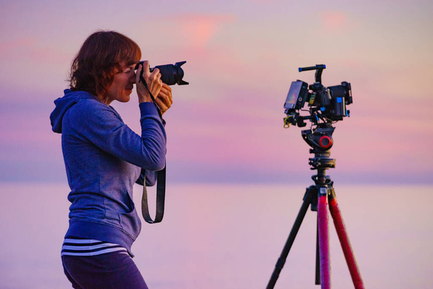 Tourist woman photographer with two cameras taking travel photo on nature at sunset time. - Foto, immagini