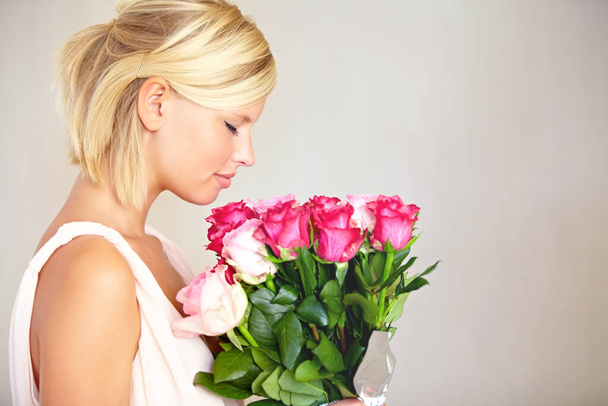 Bukiet, kobieta i róże w studio na Walentynki, prezent lub dziękuję gest na szarym tle. Świeże, róża i dziewczyna z kwiatami, szczęśliwy i zrelaksować się z kwiatowym układzie i przestrzeni kopii. - Zdjęcie, obraz