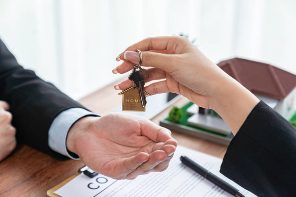 Agent nieruchomości wręczenie klucza domu do nabywcy po pomyślnym podpisaniu umowy kredytu mieszkaniowego. Właściciel oddaje klucz do domu klientowi. Podmiot - Zdjęcie, obraz