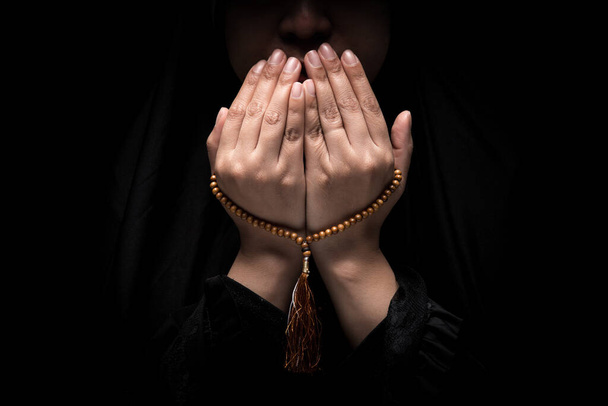 The image of a Muslim woman's hand, Islamic prayer, and her hand holding a rosary beads or tasbih. - Photo, image