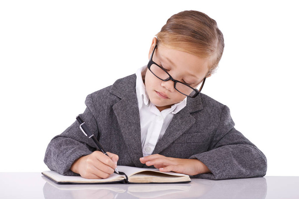 Θέλει να γίνει διάσημη συγγραφέας. Ένα χαριτωμένο κοριτσάκι που γράφει στο σημειωματάριό της. - Φωτογραφία, εικόνα