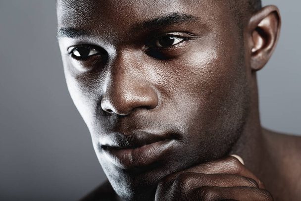 Beauty, skin care and face of black man on dark background with male cosmetics, strong and serious glow closeup. Health, wellness and dermatology, African skincare model isolated on studio backdrop - Foto, imagen