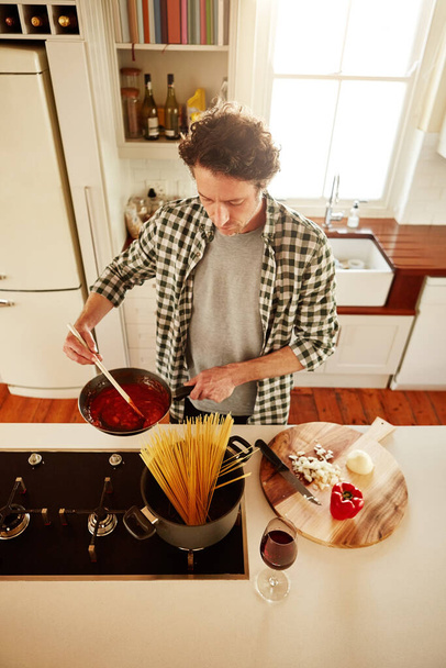 Spaghetti, cooking or above of man in kitchen with healthy vegan diet for nutrition or vegetables at home in Australia. Wine glass, food or male person in house kitchen in preparation for dinner meal. - Foto, Imagem