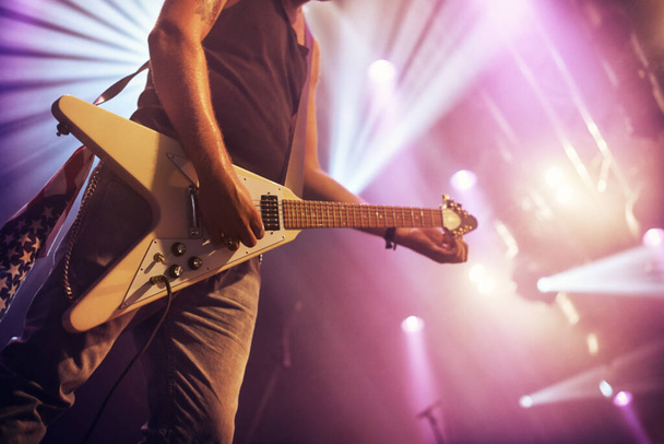 Guitar, man and performance for concert, rock or singing at party, event or celebration in night. Male musician, artist or rockstar with instrument at music festival for art, sound or talent on stage. - Foto, imagen