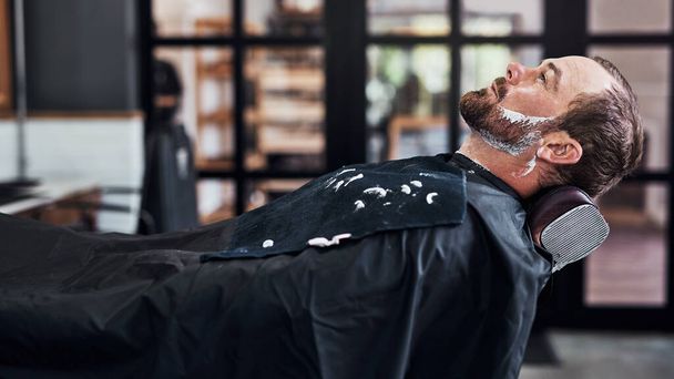 Theres no excuse for not looking your best. a handsome mature man getting his beard trimmed and lined up at a barbershop - Photo, Image