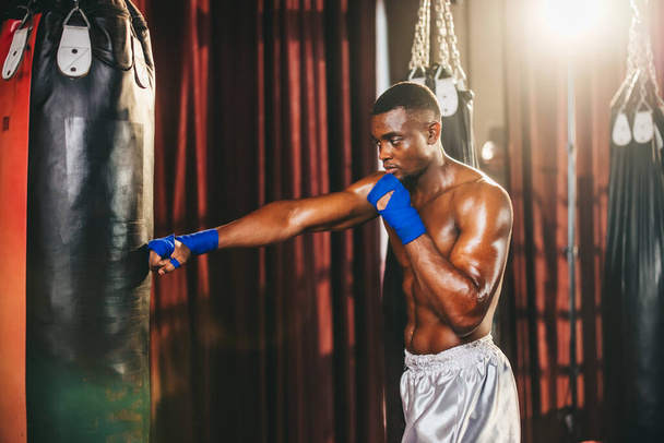 Boxers at the professional level routinely train by punching and kicking sandbags. To be successful in the individual's career, self-discipline, determination, and patience are essential qualities. - Foto, Imagem
