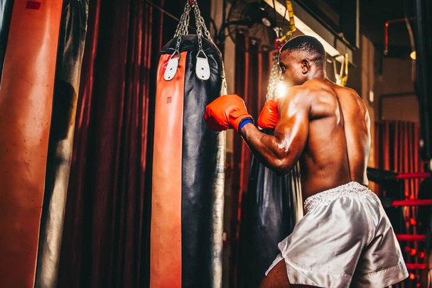 Boxers at the professional level routinely train by punching and kicking sandbags. To be successful in the individual's career, self-discipline, determination, and patience are essential qualities. - Foto, immagini