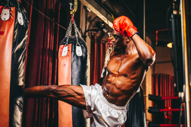 Los boxeadores a nivel profesional entrenan rutinariamente golpeando y pateando sacos de arena. Tener éxito en la carrera del individuo, la autodisciplina, la determinación y la paciencia son cualidades esenciales.. - Foto, imagen