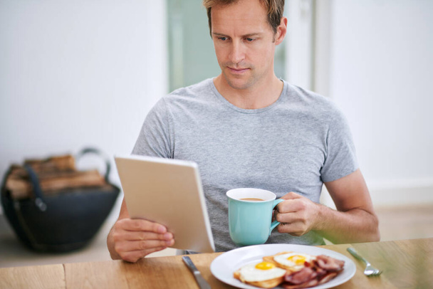 BampB- Frühstück und Stöbern. ein gutaussehender Mann entspannt sich zu Hause - Foto, Bild
