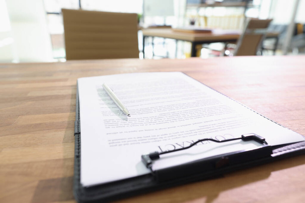 契約書とペンはオフィスの木製のテーブルの上にあります。規則との契約の概念と会社における重要な決定 - 写真・画像