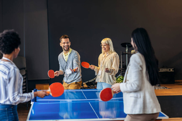 Νέοι που παίζουν πινγκ-πονγκ στο γραφείο στη δουλειά - Φωτογραφία, εικόνα