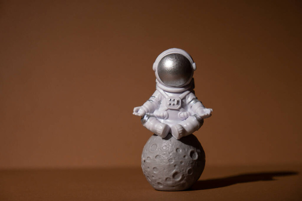 Plastic toy figure astronaut on beige neutral background Copy space. Concept of out of earth travel, private spaceman commercial flights. Space missions and Sustainability - Fotografie, Obrázek