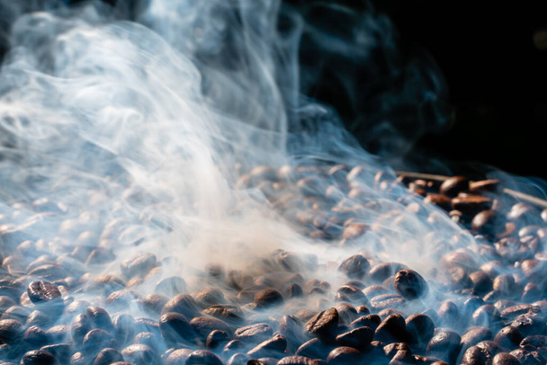 Κόκκοι καφέ ψήσιμο με καπνό, επιλεκτική εστίαση, και απαλή εστίαση. - Φωτογραφία, εικόνα