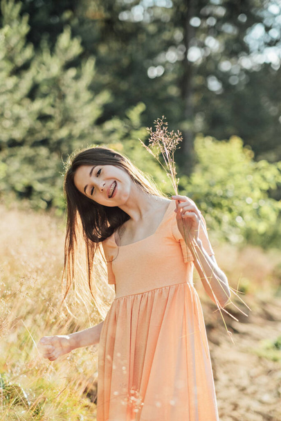 Positive emotions like happiness, excitement, joy, hope, and inspiration is vital for happy and healthy life. Outdoor portrait of happy smiling young woman in nature background. - Photo, Image