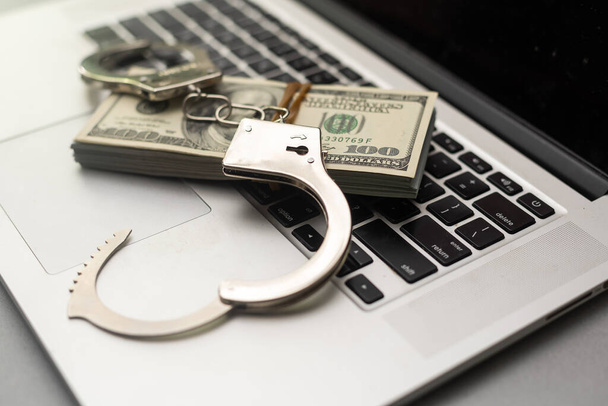 Handcuffs keyboard and dollars above. - Photo, Image