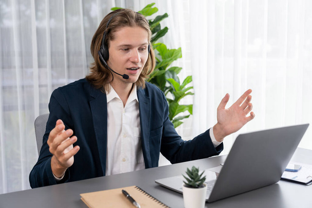 Male customer service operator or telesales agent sitting at desk in office, wearing headset and engage in conversation with client to provide support or close sales. Call center portrait. Entity - Fotografie, Obrázek