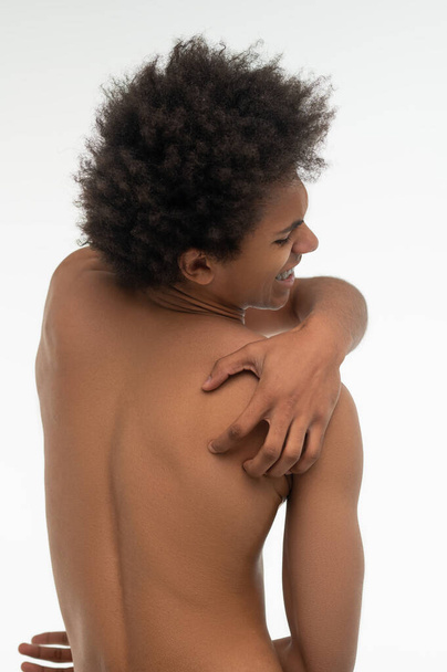 Back pain. Curly-haired african american guy suffering from pain in his back - Fotó, kép
