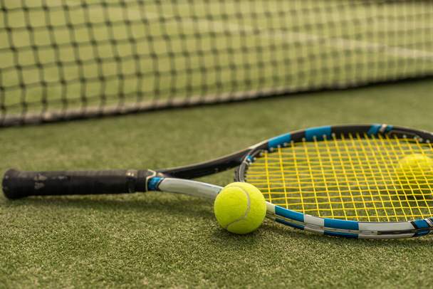 Tennisschläger mit Tennisball auf einem Tennisplatz. - Foto, Bild