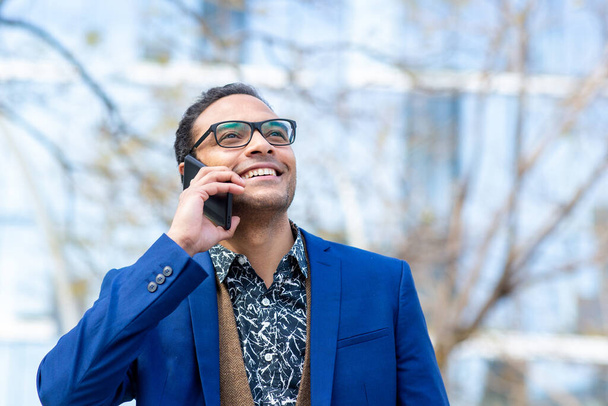 Close up portrait of smiling african american businessman talking on mobile phone in city - Fotografie, Obrázek