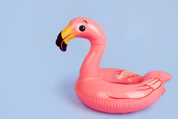 Inflatable flamingo on a blue background, a beach toy. Summer background with copy space.  - Fotó, kép