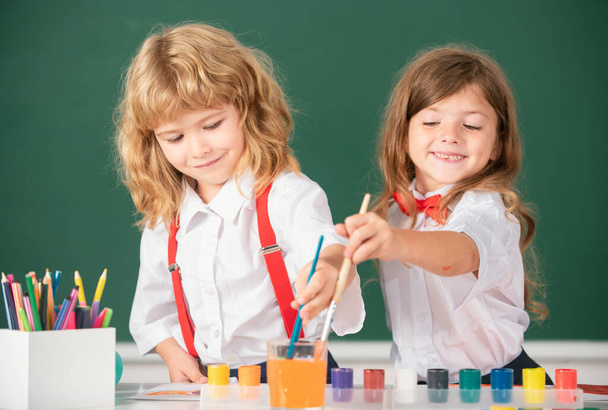 School children drawing a colorful pictures with pencil crayons in classroom. Portrait of cute pupils enjoying art and craft lesson. Kids art, creativity children concept - Фото, зображення