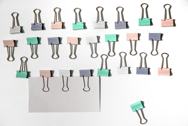 white note hold by metal paper clips isolated over white background, business concept, memory reminder paper, work or educational tools. High quality photo - Foto, immagini