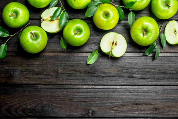 Green apples with leaves and Apple slices. On wooden background. - Foto, immagini