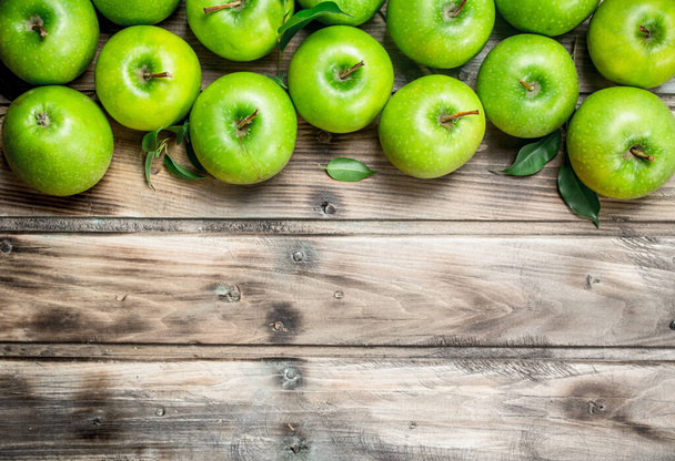 Green fresh apples with leaves. On grey wooden background. - Foto, Imagen