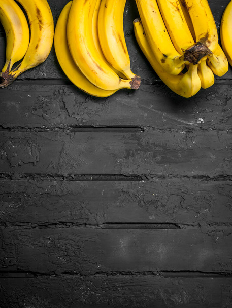 Whole fresh bananas. On black rustic background. - Photo, image