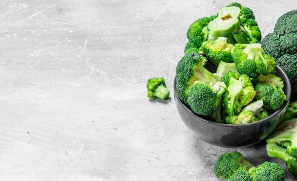 Broccoli in a bowl. On rustic background. - Foto, Imagen