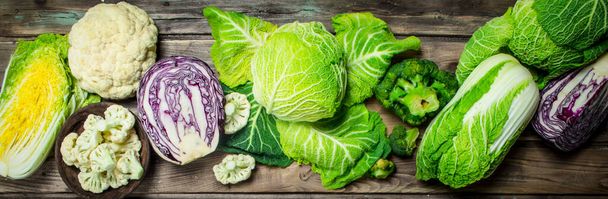 Lot of fresh juicy cabbage. On a wooden background. - Foto, Bild