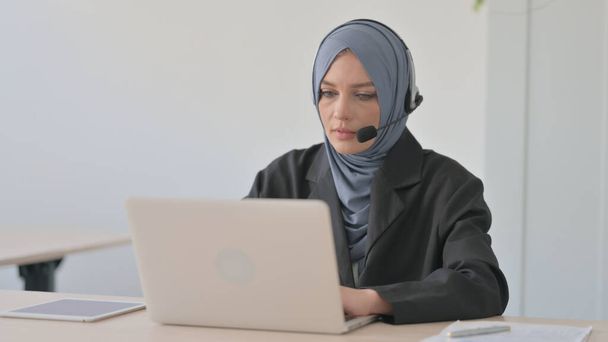 Muslim Businesswoman with Headset Working on Laptop - Foto, afbeelding