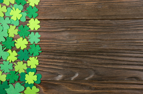 Happy Saint Patrick's mockup of handmade felt shamrock clover leaves on wooden background.  - Fotó, kép