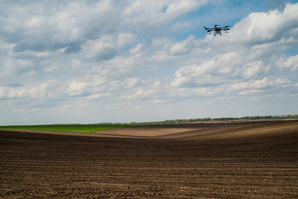 agrodrone, agrocopter sprays arable fields on the background of a beautiful sky, the concept of modern agriculture - Foto, Imagen