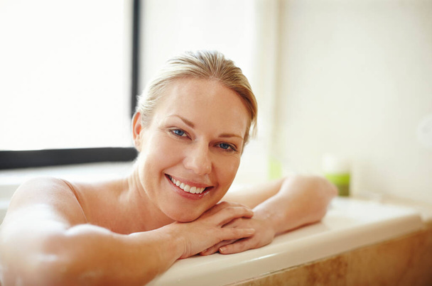 Happiness is a warm bath. A gorgeous young woman relaxing happily in a bathtub - Zdjęcie, obraz