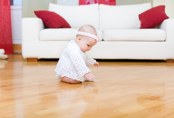 Happy baby girl touch a hardwood floor - Foto, imagen