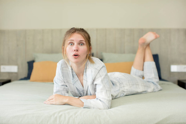 young pretty woman feeling extremely shocked and surprised. nightwear concept - Valokuva, kuva