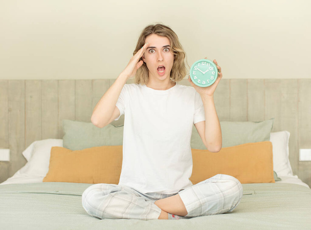 pretty woman looking happy, astonished and surprised alarm clock concept - Photo, Image