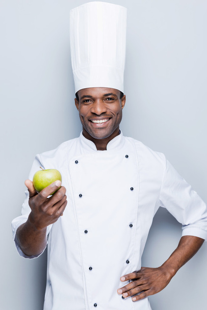 African chef  stretching out  apple - Foto, Imagem