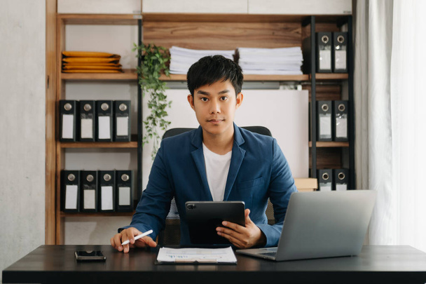 businessman executive manager with laptop and tablet pc watching online webinar training or having virtual meeting video conference doing market research working in modern office. - 写真・画像